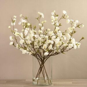 زهور كرز صناعية في مزهرية زجاجية