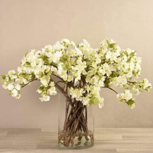 أغصان أزهار شجرية صناعية في مزهرية زجاجية