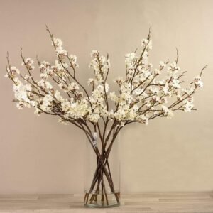 أغصان زهور صناعية في مزهرية زجاجية