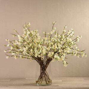 أغصان أزهار صناعية داخل مزهرية زجاجية