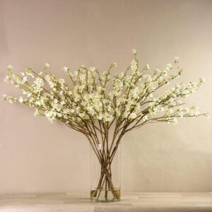 فروع أزهار شجرية صناعية في مزهرية زجاجية