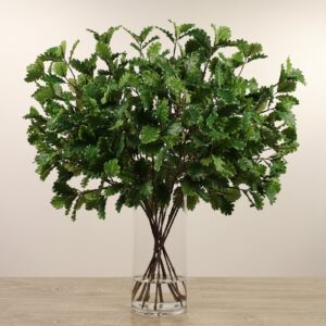 أوراق بلوط صناعية صغيرة مرتبة في مزهرية زجاجية